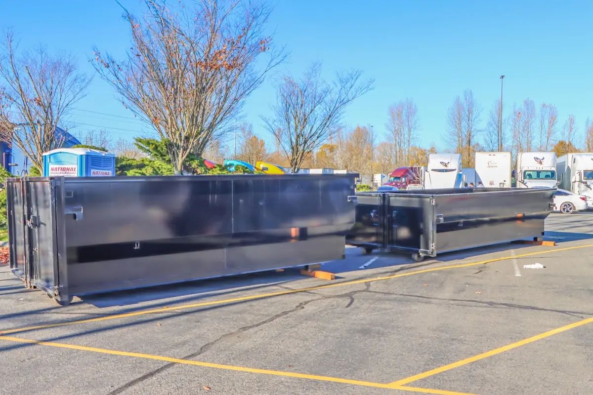 Professional dumpster rental service with roll-off container on residential driveway in Highwood